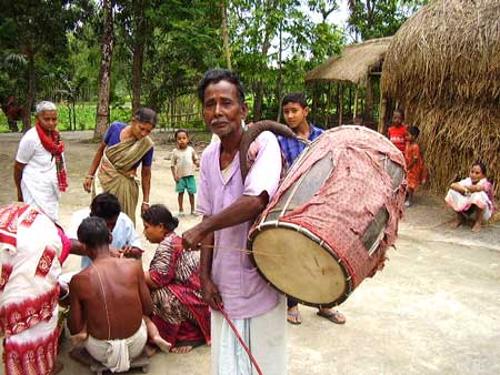 A dhol player performing in a village func­tion